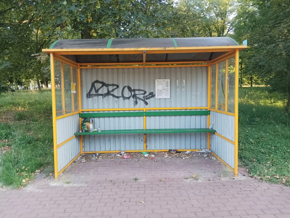 Zarośnięty park i zaśmiecony przystanek. Na wieży wyrwane barierki